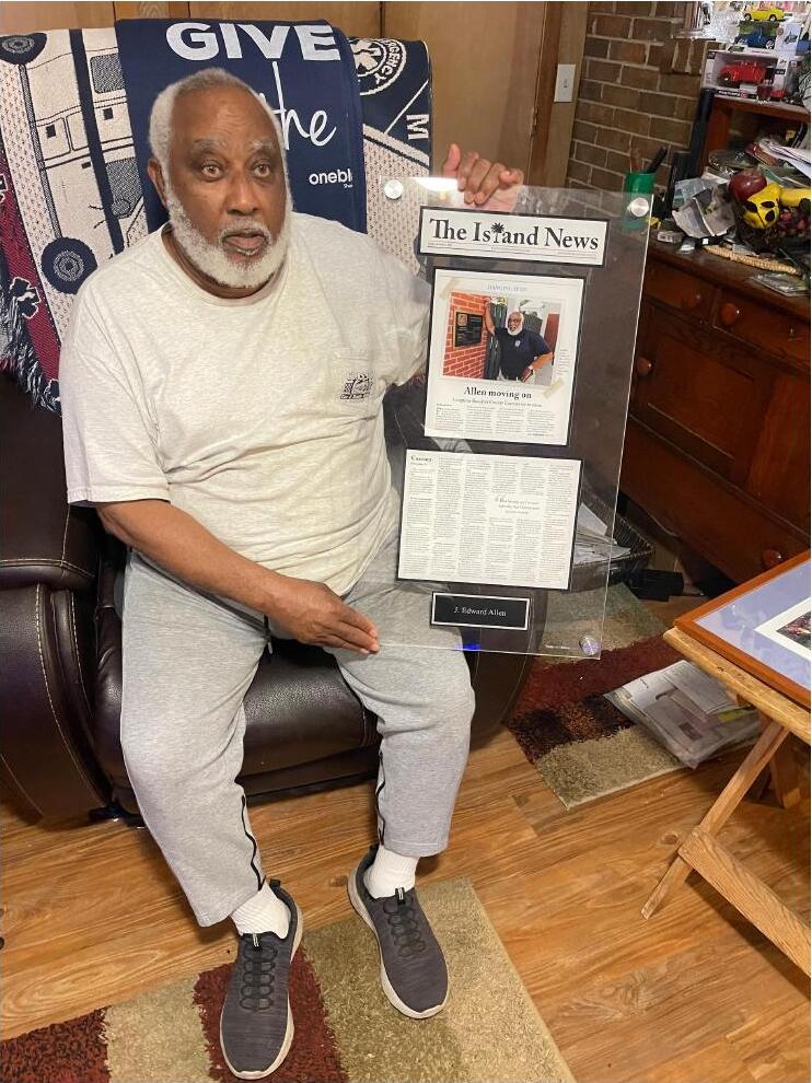 Mr. Ed Allen holding a framed Island News article